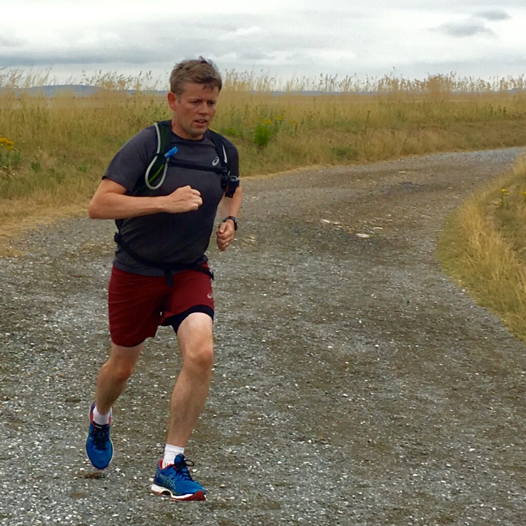 Tim running on a gravel path in the North Wales countryside
